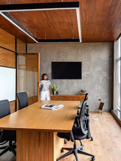 Another view of the discussion room, showing the seamless flow from the guest area. The design balances the warmth of wood with the raw texture of cement, creating a sophisticated and practical environment for collaboration.
