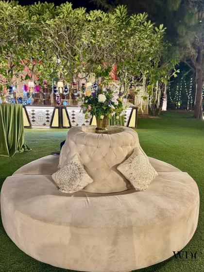 A luxurious and comfortable ivory suede round sofa, providing a chic and inviting seating area for guests to lounge and socialize.