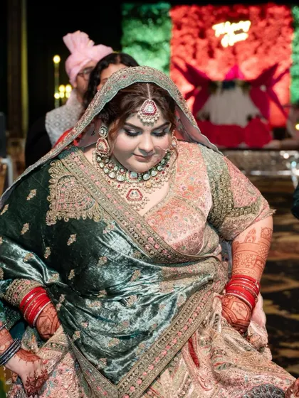 A full-length shot of a beautiful bride, where the rich color of her full-sleeve mehendi is clearly visible, adding to her bridal grandeur.