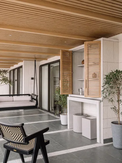 The bar area on the deck is cleverly integrated with louvered shutters. This space is designed for entertaining, offering a place to prepare drinks while enjoying the panoramic city and sea views.