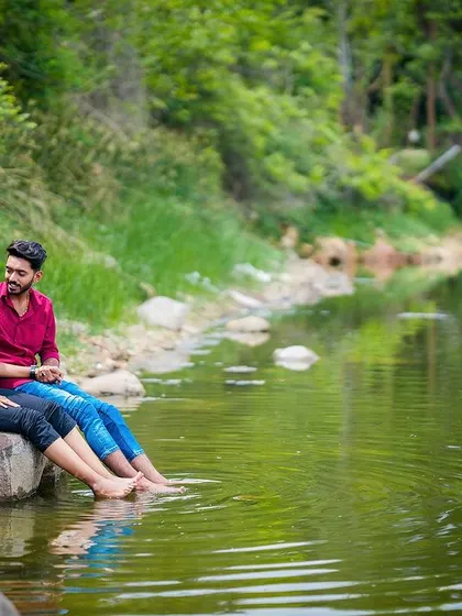 A serene pre-wedding moment with a couple enjoying a quiet time by the lake, their feet dipped in the water.