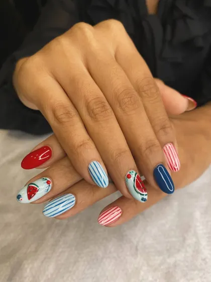 Get ready for summer with this fun and fruity nail art. We combined nautical stripes in red and blue with adorable, hand-painted watermelon slices for a playful and seasonal look.