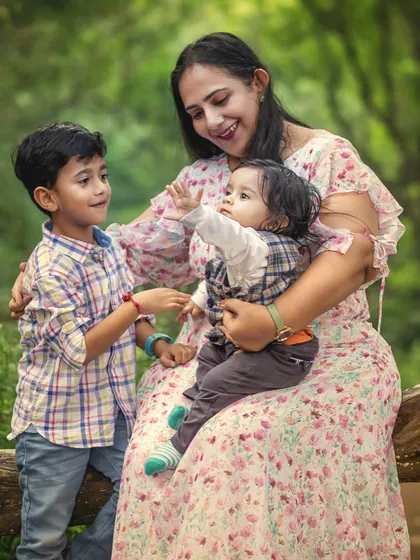A mother sits on a log in the woods, sharing a tender moment with her two young sons. This portrait showcases the warmth and connection that unfolds naturally during my outdoor sessions.