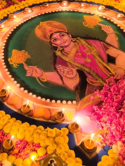 A close-up of a beautiful Durga mandala, illuminated by diyas. Every detail is crafted to please the goddess and invoke her powerful presence.