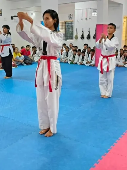 An instructor oversees students as they practice their forms.