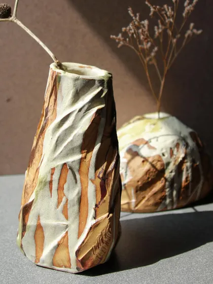A pair of Kurinuki vases, one tall and faceted, the other round and organic. Together, they showcase the versatility of this hand-building technique.