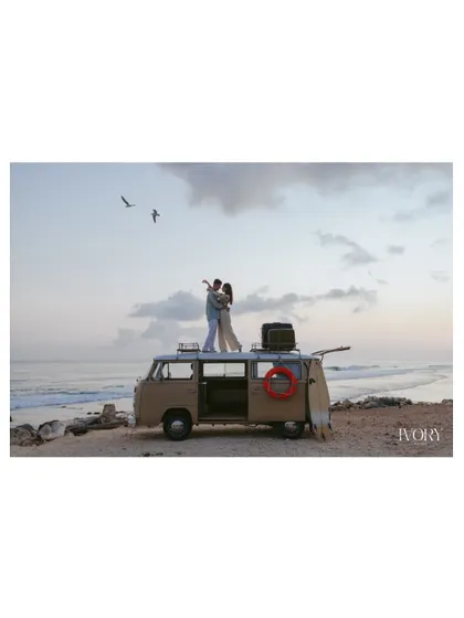 A breathtaking wide shot of the couple standing atop their vintage van, embracing against the vast Bali sky. The birds flying overhead add a sense of freedom and romance to this epic pre-wedding photograph.