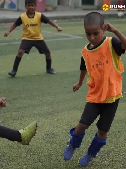 A young player attempts to get past a defender's foot.