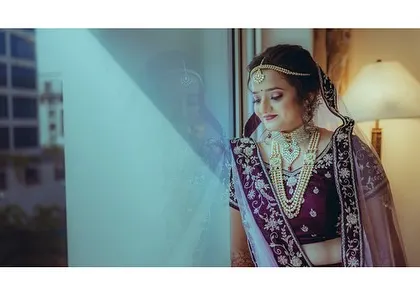 A moment of quiet reflection for the bride before the ceremony begins. The soft light from the window creates a gentle and dreamy mood.