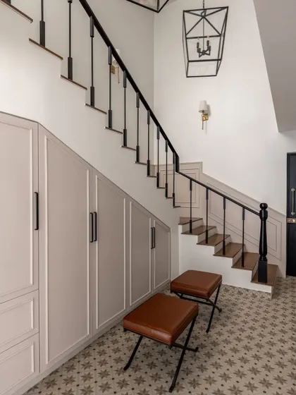 The foyer of the Rio Home introduces the modern English aesthetic with Victorian-inspired patterned floors and custom under-stair storage. This area sets the tone for the rest of the home with its blend of classic details and practical design.