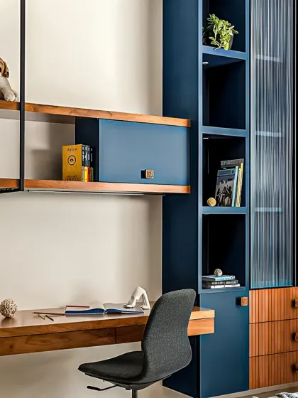 This is a perfect example of our integrated furniture solutions. We designed this study unit with a floating wooden desk, a sleek blue cabinet with fluted glass, and open shelving, creating a stylish and highly practical workspace that doesn't compromise on design.