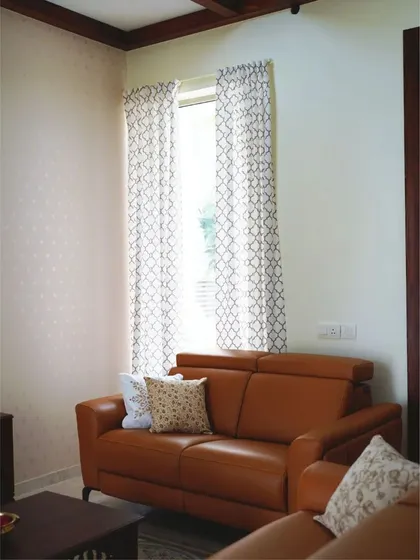 Another angle of the living room, highlighting the comfortable two-seater leather sofa and the subtle texture of the wallpaper. It's a space designed for intimate conversations and relaxation.