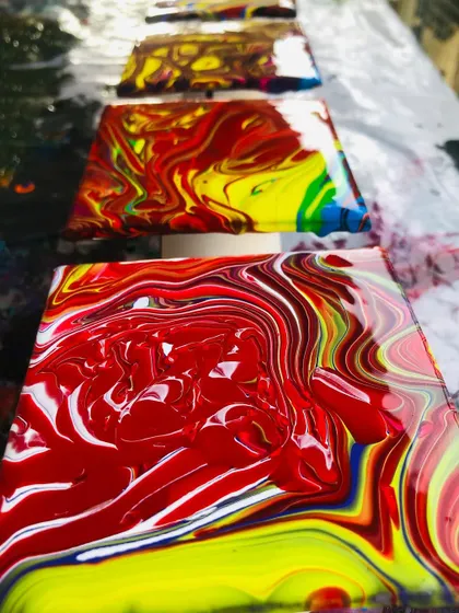 A row of freshly poured canvases, each one a unique universe of color. This is what happens when you let the paint do the talking.