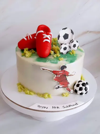 A stunning football themed cake with bright red cleats and soccer balls. The design is simple, modern, and perfect for a sports fan.
