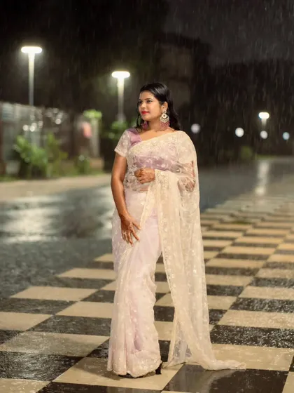 A beautiful portrait of a woman in a saree during a downpour. The rain adds a dramatic and romantic element to this night shoot.