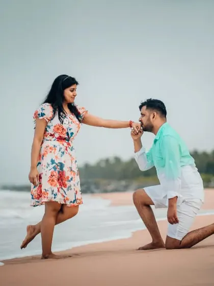 A classic proposal moment on the beach, with the groom-to-be on one knee. We capture these pivotal pre-wedding memories forever.