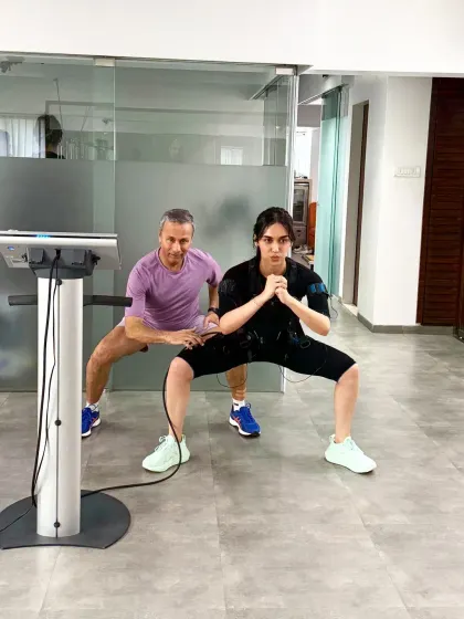 Manushi and I sync up for a squat. Training alongside clients helps with motivation and demonstrates the correct form.