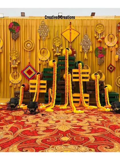 A full view of the artistic photo wall with kites and marigolds. This setup provides a fun and interactive space for guests to take pictures.