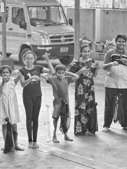 The full line-up of young puppeteers from a summer camp, ready to show off their handmade puppets. You can see the pride and excitement on their faces.