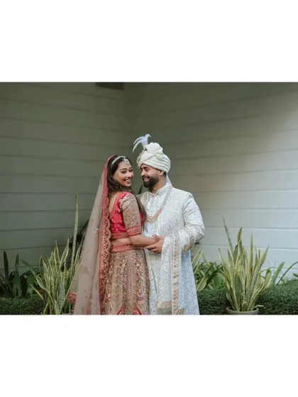 A sweet and simple portrait of the couple, sharing a smile in a garden setting.