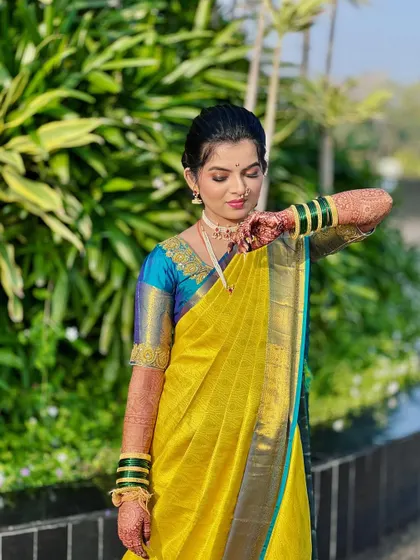 A close-up of the yellow Nauvari, showing the delicate details of the saree and the neatness of the drape.
