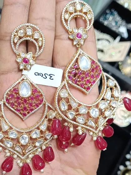 A beautiful pair of chandbali earrings with intricate ruby and kundan work. The hanging red beads add movement and elegance, making them a great choice for dancing at a sangeet or wedding.