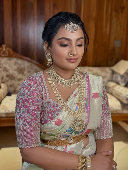 A serene moment captured during the Bangle ceremony. The makeup is understated and elegant, allowing the intricate details of her outfit to stand out.