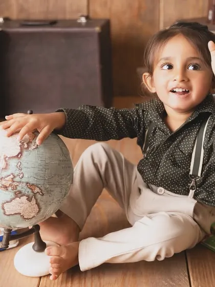 Waving goodbye as he sets off on an imaginary journey. This travel and book-themed shoot is perfect for curious little minds.