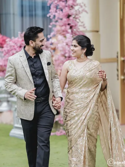 A happy, relaxed photo of the couple walking together in a beautiful garden setting during their engagement event.