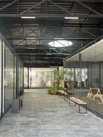 An Early Childhood Development Center should be a neutral space that allows children to evolve without the burden of a stylized environment. Our design uses a simple industrial structure with glass-walled classrooms opening onto a central, green corridor.