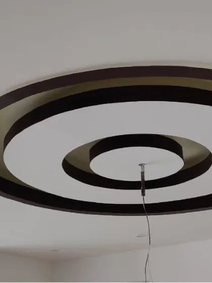 A modern false ceiling with concentric circles painted in contrasting colors. I handle detailed ceiling painting to highlight architectural features.