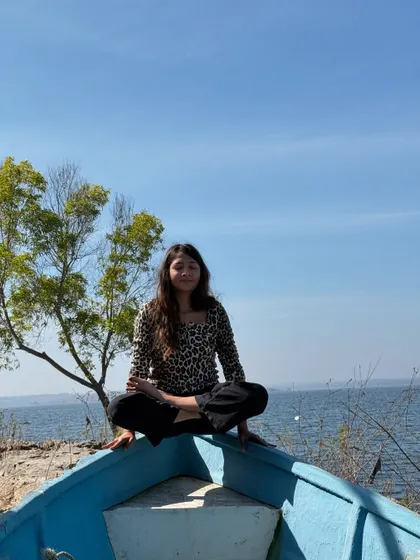 Finding a moment of playful balance on a boat. Yoga doesn't always have to be serious; sometimes it's about exploring your surroundings with curiosity.