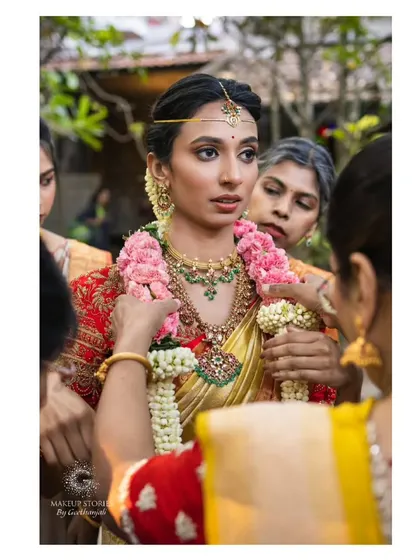 A candid moment from Ritika's wedding ceremony. Her makeup is subtle and elegant, ensuring that the focus remains on the sacred rituals and her own natural beauty.