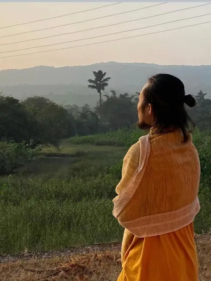 A moment of stillness, observing the serene landscape. The environment of the ashram encourages introspection and a deeper connection with oneself.