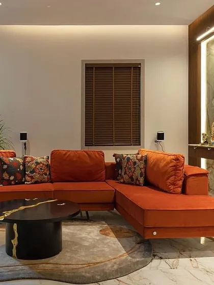 The Family Lounge furniture by WIBN. Celebrating the essence of this space's design! The chandelier continues to shine as the highlight on this floor, while the family lounge is adorned with a serene green onyx altar. A pop of joyful orange on the couch reflects the client's love for color, and don't forget to take in the allure of the stunning black and gold TV unit.