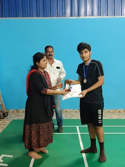 An older student from our intermediate batch receives his medal and certificate during the awards ceremony for the intra JP badminton tournament.