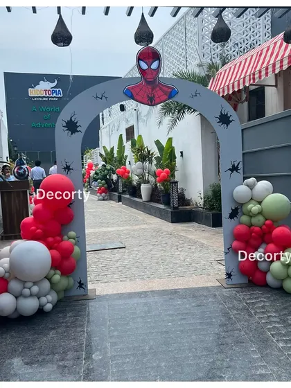 A Spider-Man themed entrance arch for a superhero party. The arch is decorated with red, green, and grey balloons to match the colors of the favorite Avengers.