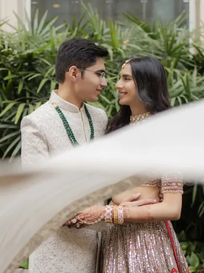 An artistic shot of the couple seen through a flowing white cloth, creating a dreamy, romantic, and intimate portrait.