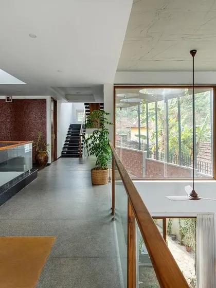 From the upper level, you can appreciate the home's open, interactive layout. The large window and double-height volume connect the floors visually and help circulate air, while the custom pendant lights add a delicate, artistic touch.
