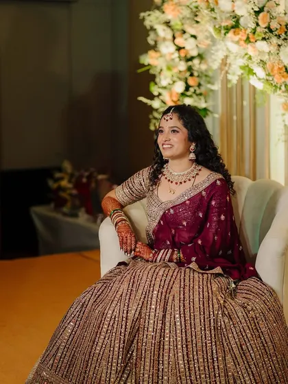 A wide shot showing the beautiful decor and the bride's stunning look. The makeup is designed to stand out and look glamorous in a large setting.
