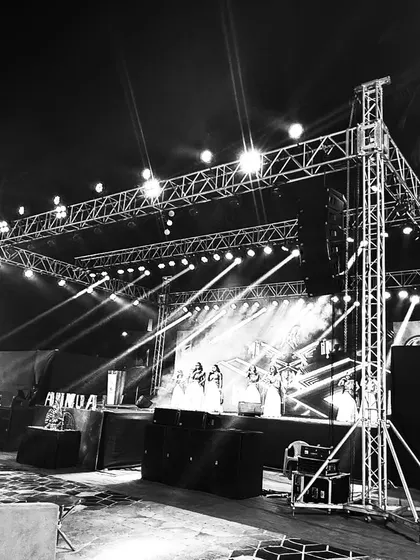 A black and white shot of a stage truss and lighting rig, highlighting the structural engineering that goes into every concert setup. Safety and stability are our top priorities.