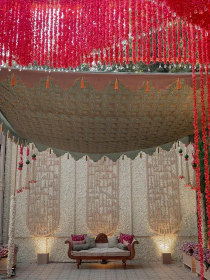 For this event, we created a serene backdrop using panels with intricate, hand-carved textures. The space is decorated with traditional Indian seating and brass pots filled with tuberoses.