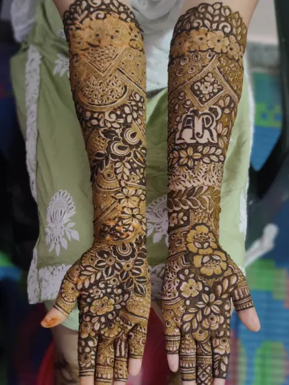 Another beautiful bridal design featuring the initials 'A' and 'R' hidden within the floral patterns. Personalizing henna is a popular request for weddings and engagements.