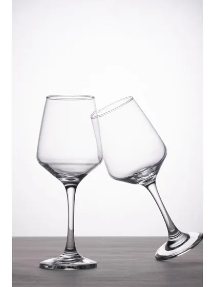 A playful composition of two wine glasses, with one leaning against the other. This simple creative touch adds personality to a standard product shot, making it more engaging.