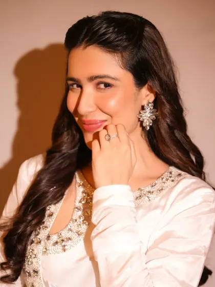 A soft and angelic look. The makeup here is minimal and fresh, with a focus on glowing skin and a gentle pink lip to complement the white embellished outfit.