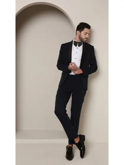 The relaxed yet confident stance in the Prism Riviera tuxedo. The custom tailoring ensures a perfect fit, allowing the unique beadwork and rich teal color to take center stage.