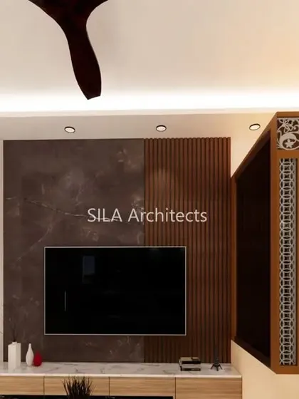 Another angle of the JP Nagar living room, focusing on the TV wall which combines dark marble and fluted wood panels.