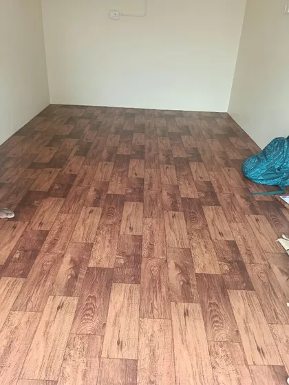 The installation of durable, wood-patterned flooring in an outdoor room. This type of flooring gives the warm appearance of wood but is built to withstand outdoor weather conditions.