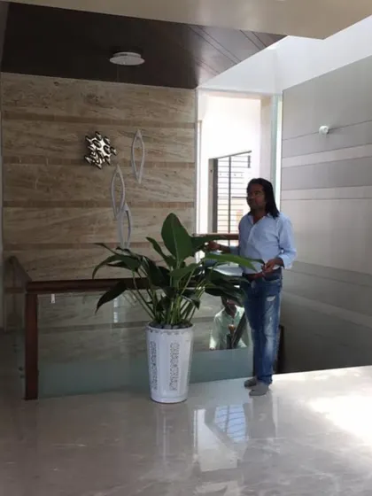 Here I am placing a large Bird of Paradise plant in a white decorative pot. This type of tall, elegant plant is ideal for spaces with high ceilings, like this staircase landing, to draw the eye upward.