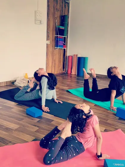 Young girls practicing a variation of Eka Pada Rajakapotasana, or One Legged King Pigeon Pose. Their flexibility and focus are remarkable.